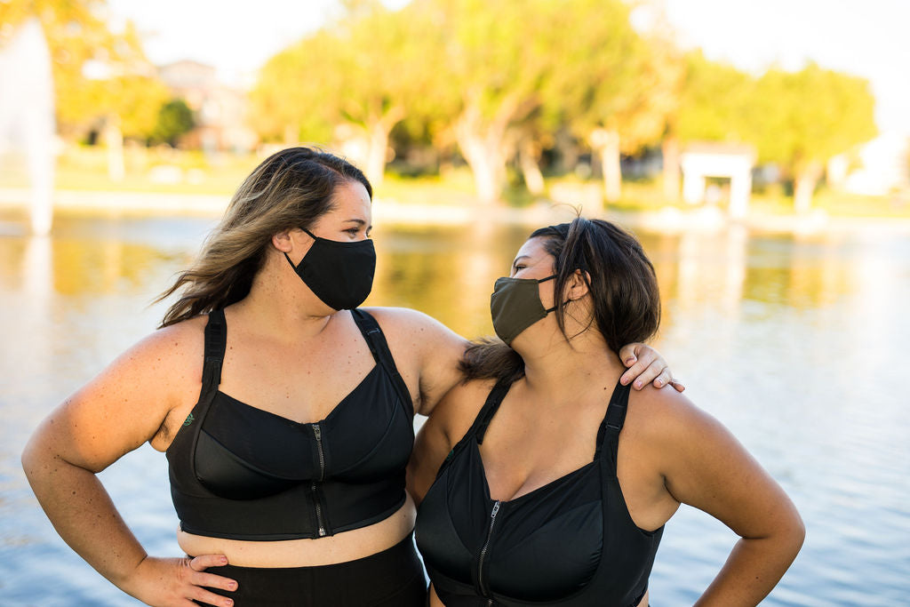 two friends wearing masks smiling on lake front in their bloom bra