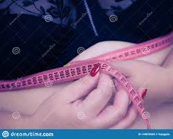 measuring tape around woman's bust to help size her for bra